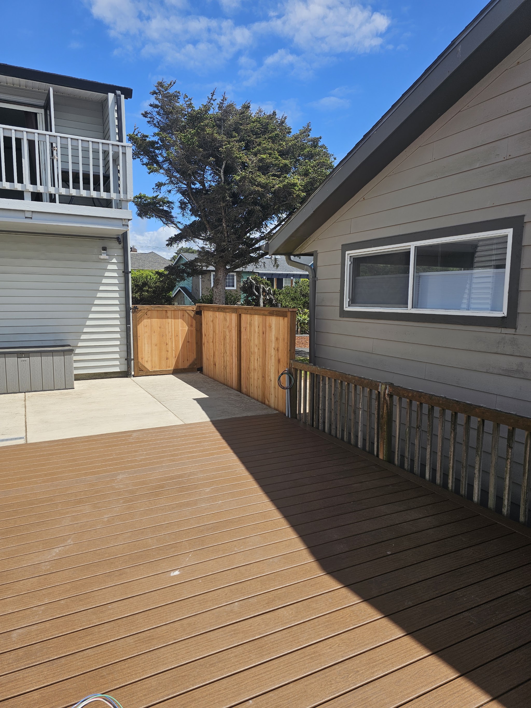 A finished composite deck with a cedar fence and gate